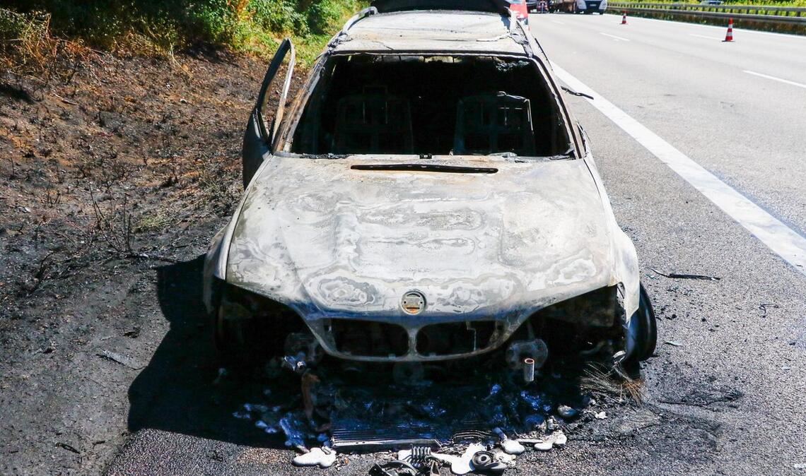 Der BMW wird durch das Feuer, das auf die Böschung übergreift, völlig zerstört. Foto: Einsatz-Report 24
