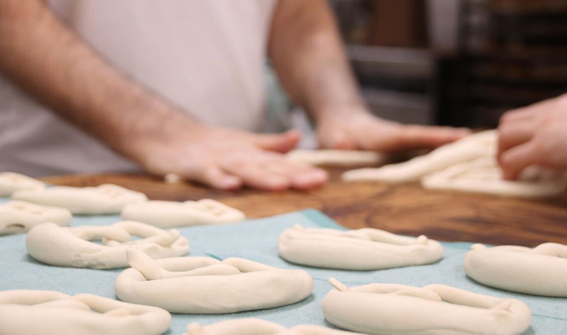 Der Brezelteig wird von einer Maschine gleichmäßig portioniert, ausgerollt und dann von den Bäckermeistern Martin Reinhardt und Marc Schlosser in Form gebracht. Fotos: von Wagner