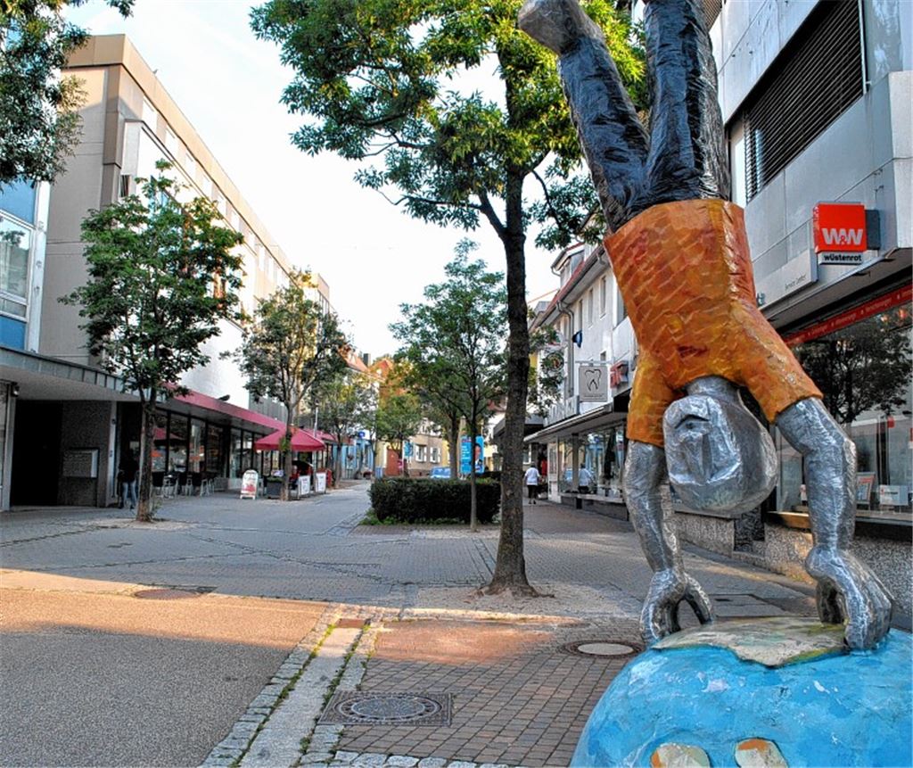 Der Eindruck täuscht: Auf der Bahnhofstraße steht um 8.30 Uhr nicht nur das Kunstwerk vor der Sparkasse Kopf. Die Geschäftsinhaber bereiten sich auf ihren Arbeitstag vor. Fotos: Stahlfeld