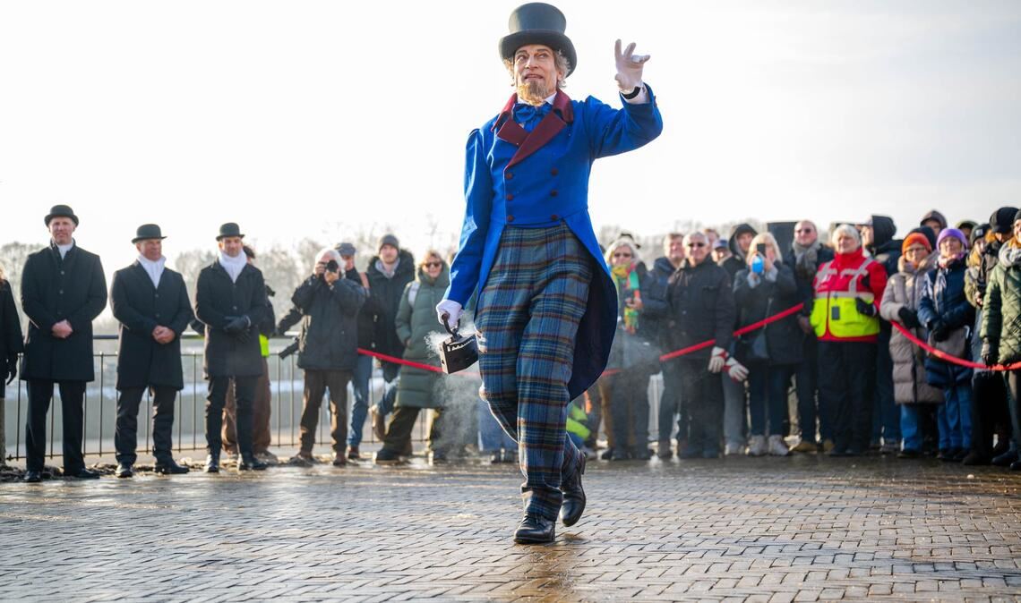 Der Eiswettenschneider gestikuliert am Ufer der Weser.