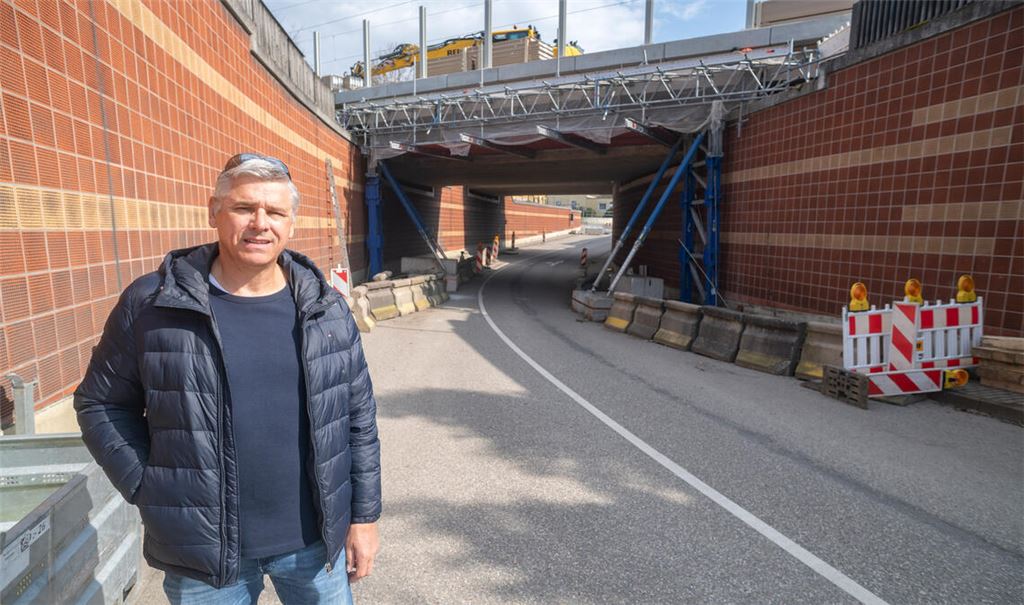 Der Enzberger Stadtrat Frank Alber vor der abgeriegelten Bahnunterführung in Enzberg. Er weist auf die große Abhängigkeit des Stadtteils von der Unterführung hin und kritisiert nebenbei die Beschilderung rund um die Sperrung, die beispielsweise „mit zu kleiner Schrift und wenig aktuellen Datumsangaben“ zur Baustelle aufwarte. Fotos: Fotomoment
