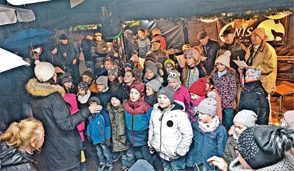 Der Grundschul-Kooperationschor der Heckengäuschule und des Männergesangvereins erfreut die Marktbesucher in Iptingen mit weihnachtlichen Liedern. Foto: Bischoff-Krappel