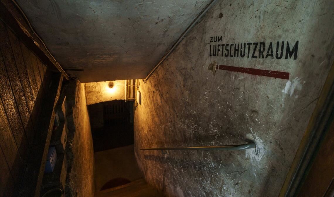 Der Hinweis „Zum Luftschutzraum“ ist an der Wand einer Kellertreppe angebracht. Wie hier im Frankfurter Stadtgebiet zeugen zahlreiche Bunker vom Zweiten Weltkrieg.