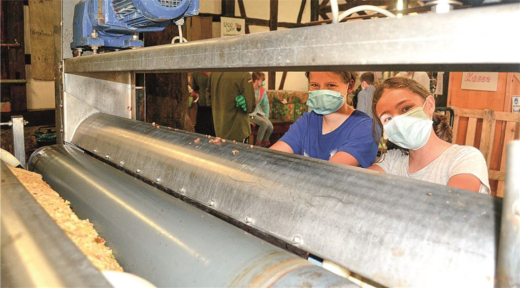 Der Kelterbetrieb in Lomersheim läuft: Auch Lia (li.) und Mailin helfen bei der Arbeit an der Bandpresse, die aus Knittlinger Beständen stammt, mit. Fotos: Stahlfeld