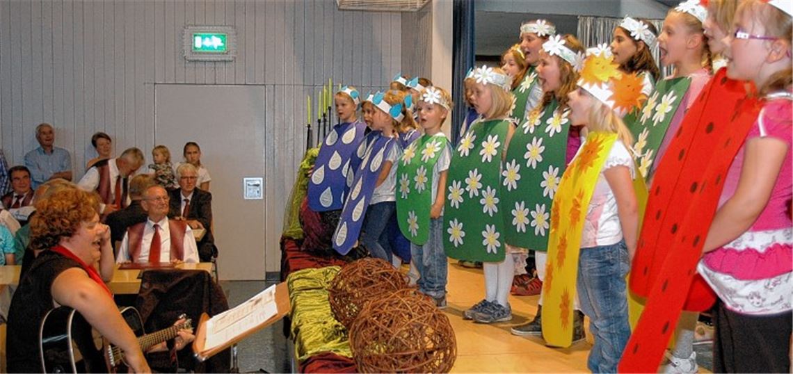 Der Kinderchor „Rabensingers“, der in diesem Jahr seinen 40. Geburtstag feiert, glänzt mit der Premiere seines neuen Musicals um Frederike, das Gänseblümchen. Links: Chorleiterin Claudia Zimmermann, die die Kinder auf der Gitarre begleitet.