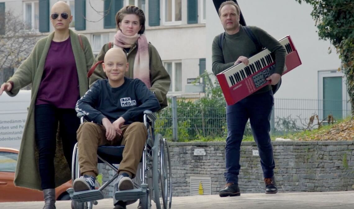 Der Kinderdarsteller Paolo Durst (im Rollstuhl sitzend) spielt in der studentischen Filmproduktion „Die Glatzköpfe“ einen krebskranken Jungen mit Rockstar-Ambitionen.