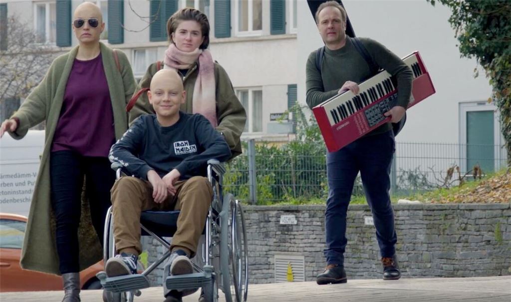 Der Kinderdarsteller Paolo Durst (im Rollstuhl sitzend) spielt in der studentischen Filmproduktion „Die Glatzköpfe“ einen krebskranken Jungen mit Rockstar-Ambitionen.