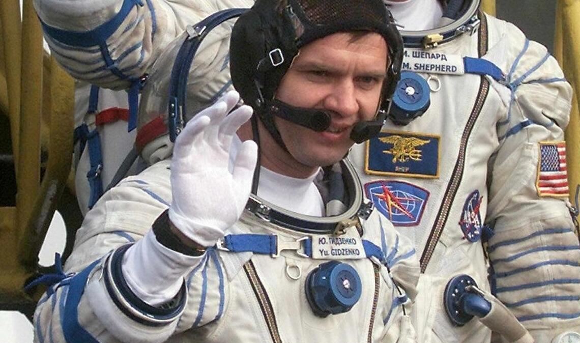 Der Kommandant der ersten Langzeitmission zur Internationalen Raumstation, der amerikanische Astronaut Bill Shepherd (M), und die russischen Kosmonauten Juri Gidsenko (unten) und Sergej Krikaljow (oben) winken, bevor sie auf dem Kosmodrom in das Raumschiff "Sojus-TM-31" einsteigen. (Archivbild)