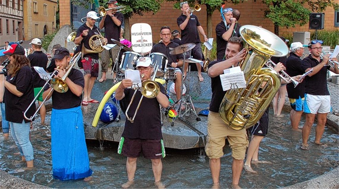 Der MV Mühlacker planscht und musiziert fröhlich im Brunnen auf dem Kelterplatz. 