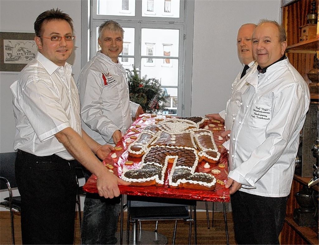 Der Produzent des Großen Dambedei, Jens Meeh, der Obermeister der Bäckerinnung, Martin Reinhardt, und dessen Stellvertreter Stefan Steiner übergeben die gebackene Auszeichnung an Rolf Nagel (v. li.). Foto: Appich