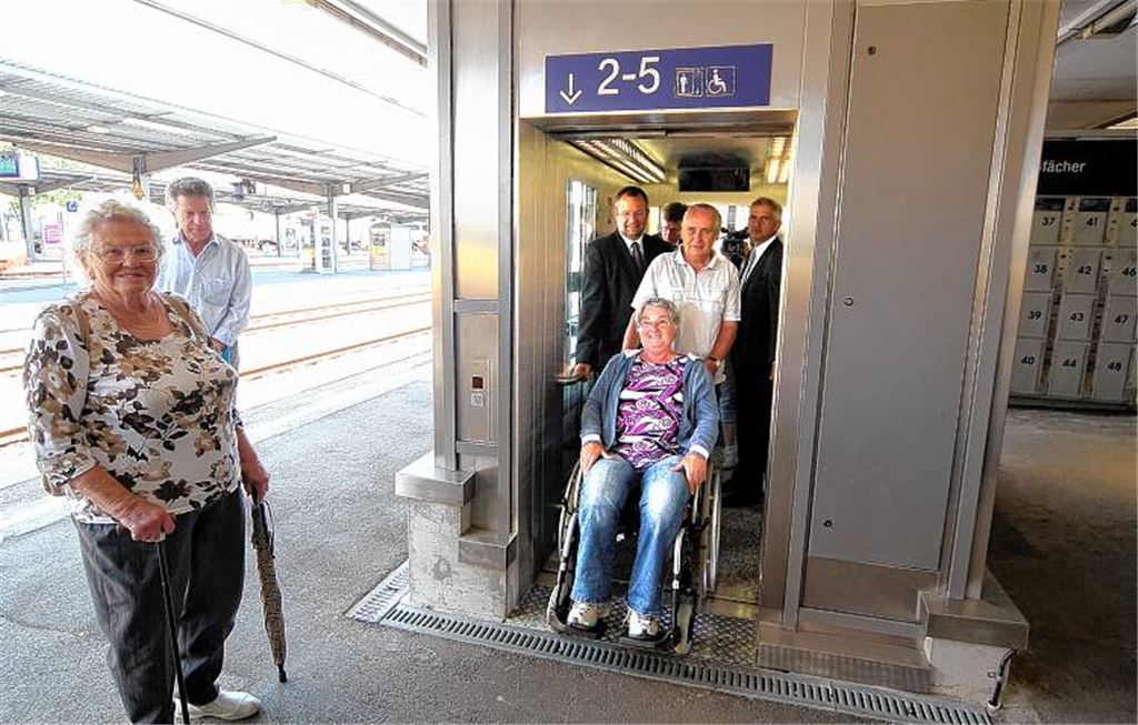 Der Rollstuhlfahrerin Hannelore Mauer, geschoben von Rudolf Feitenhansel, war die „Jungfernfahrt“ im Aufzug zusammen mit OB Hager (li.) und Bahnhof-Manager Hantel vergönnt.