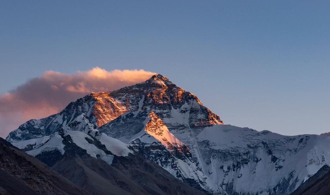 Der Sonnenuntergang färbt den Gipfel des Mount Everest.