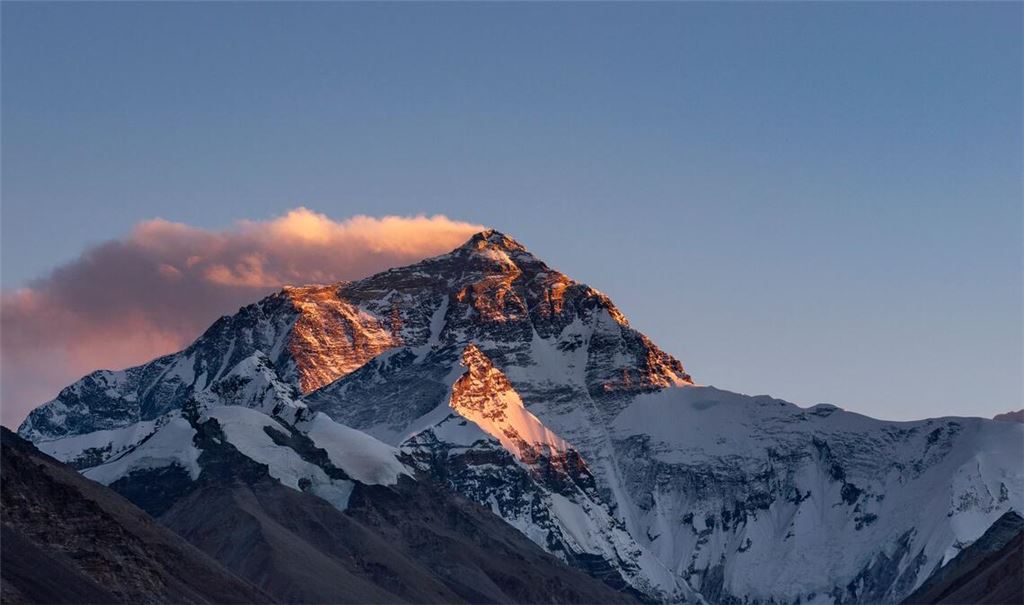 Der Sonnenuntergang färbt den Gipfel des Mount Everest.