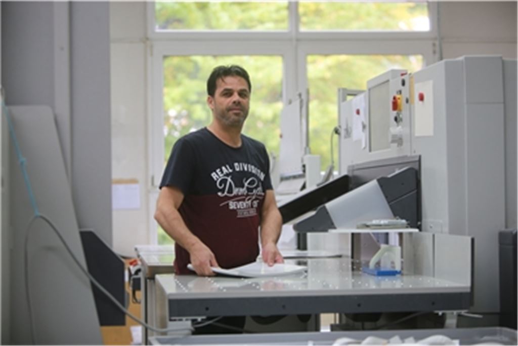 Der Syrer Khaled Fath Essouk arbeitet seit dreieinhalb Jahren als Buchbinder in der Druckerei Elser. Foto: Deeg