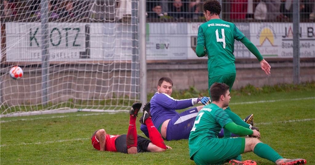Der Tormann von Zaisersweiher im violetten Dress, Tobias Jäger, sieht zuerst Sportfreunde-Kapitän Kai Müller am Boden (rotes Trikot) und anschließend den Ball im Netz zappeln. Müller kann in der ersten Hälfte gleich zweimal zuschlagen, diese Szene zeigt das 0:2 des Fußballers in der 36. Minute. Foto: Fotomoment