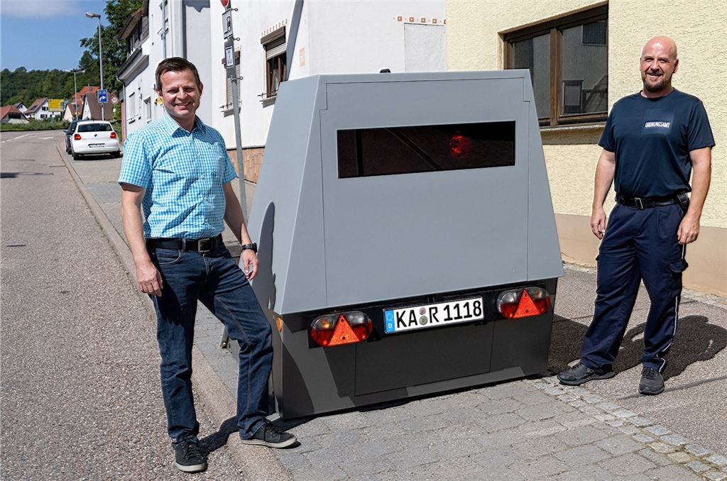 Der Vollzugsbedienstete der Gemeinde Mönsheim, Dirk Albrecht (re.), und der Leiter des Straßenverkehrs- und Ordnungsamtes des Enzkreises, Oliver Müller, mit dem Blitzgerät namens „Bert“.privat