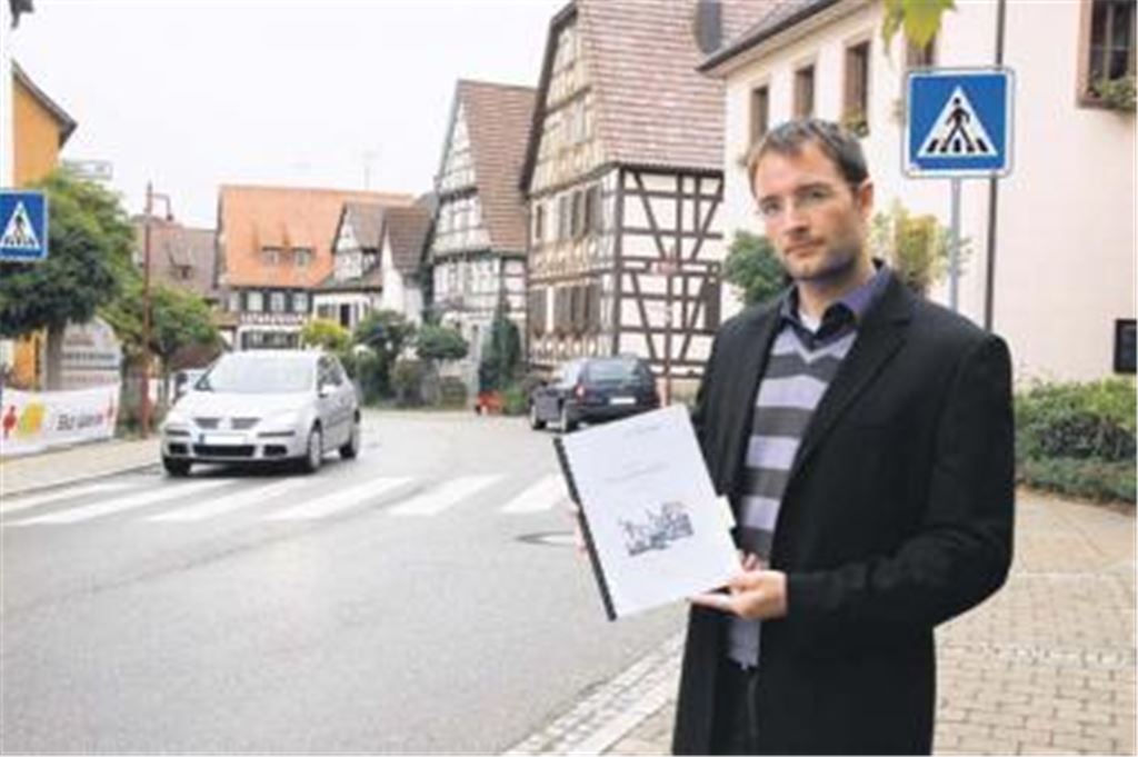 Der Wiernsheimer Hauptamtsleiter Markus Motschenbacher mit dem vor zwei Jahren vorgestellten Grobkonzept für eine umweltfreundliche Mobilität an der Wiernsheimer Ortsdurchfahrt vor dem Rathaus. Einige Vorschläge sind bereits umgesetzt. Ein Bürgerbuss mit ehrenamtlichen Fahrern wird bald starten.
Foto: Franz