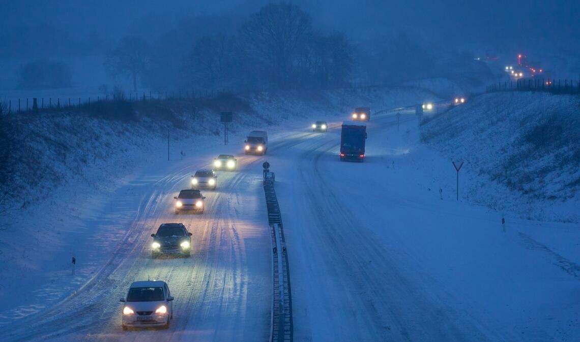 Der Winter ist zurück: Autos fahren auf einer verschneiten Straße in Fahrtrichtung Rennerod in Rheinland-Pfalz.