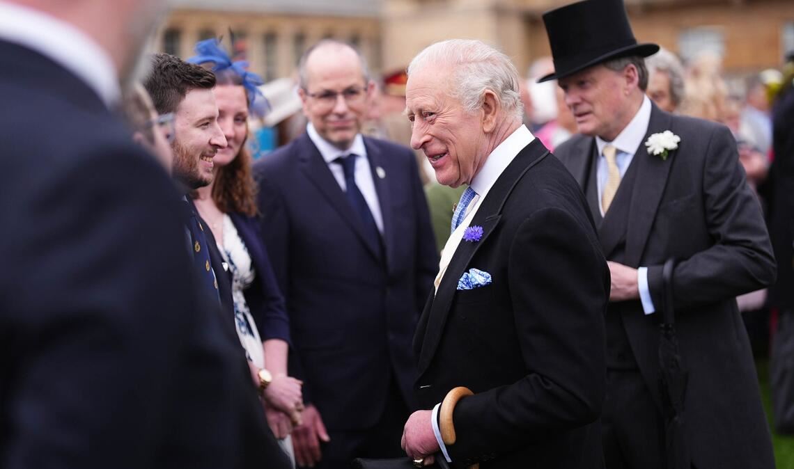 Der britische König Charles III. (M.) unterhält sich mit Gästen während der jährlichen Gartenparty im Buckingham Palace.