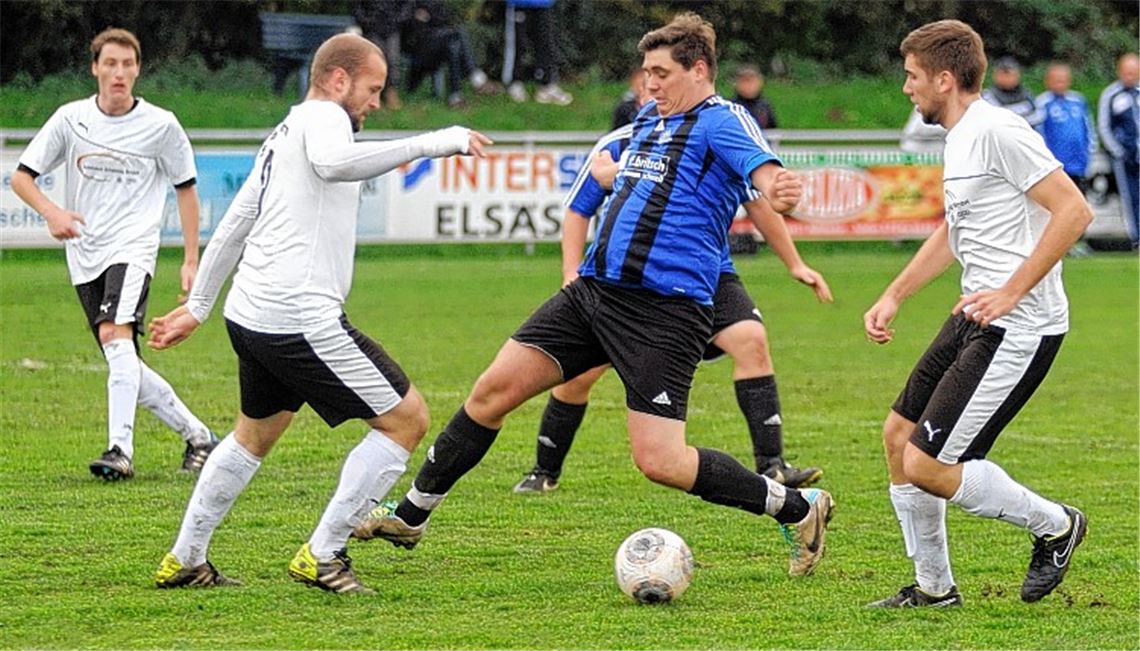 Der bullige Viktoria-Stürmer Raffael Fischer (in Blau) wird von der Ölbronn-Dürrner Defensivabteilung weitgehend abgemeldet.