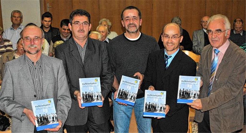 Der evangelische Pfarrer Wolfgang Schlecht, Vorsitzender Michael Klein vom Verein Junger Siebenbürger, Autor Dr. Karl Mayer, Bürgermeister Harald Eiberger und Franz Hebeda, Laienvorsitzender der katholischen Gemeinde, stellen das Buch „Aufbruchjahre“ vor (v. li.). 