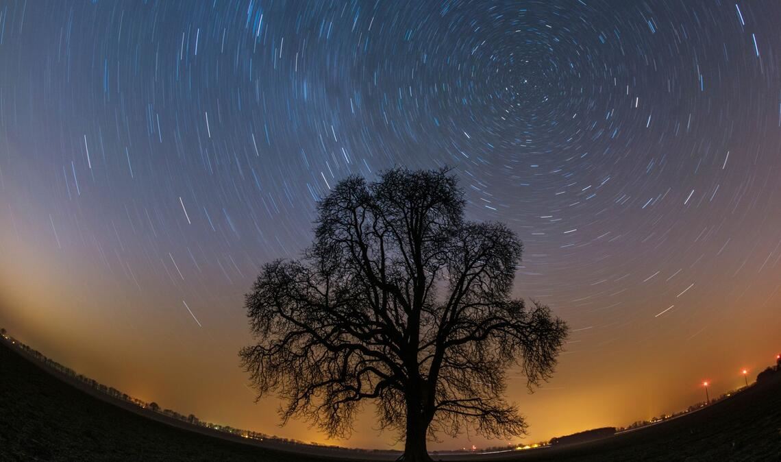 Der  gesamte Himmel scheint sich auf diesem Bild um den Polarstern zu drehen. Dabei bilden die Sterne auf ihrer Umlaufbahn einen Kreisbogen, je weiter sie vom Polarstern entfernt sind, um so größer wird auch der Kreisradius.