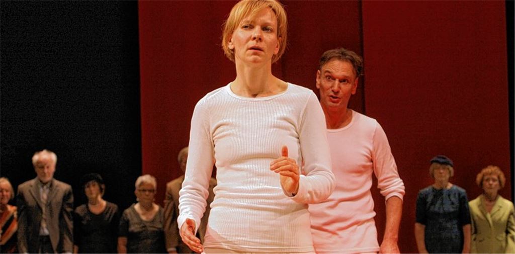 Der im Hintergrund zu sehende „Laien-Sprechchor“ aus insgesamt 14 Senioren aus der Stadt Pforzheim und der Umgebung spielt eine wichtige Rolle in der Inszenierung.