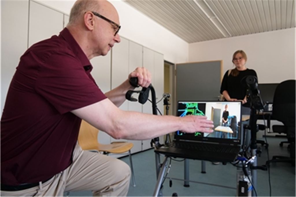 Der intelligente Rollator erkennt Hindernisse auf dem Weg und übermittelt eine Warnung an den Nutzer, demonstriert Thomas Greiner mit Hilfe von Pressesprecherin Jeanne Lutz. Foto: Friedrich