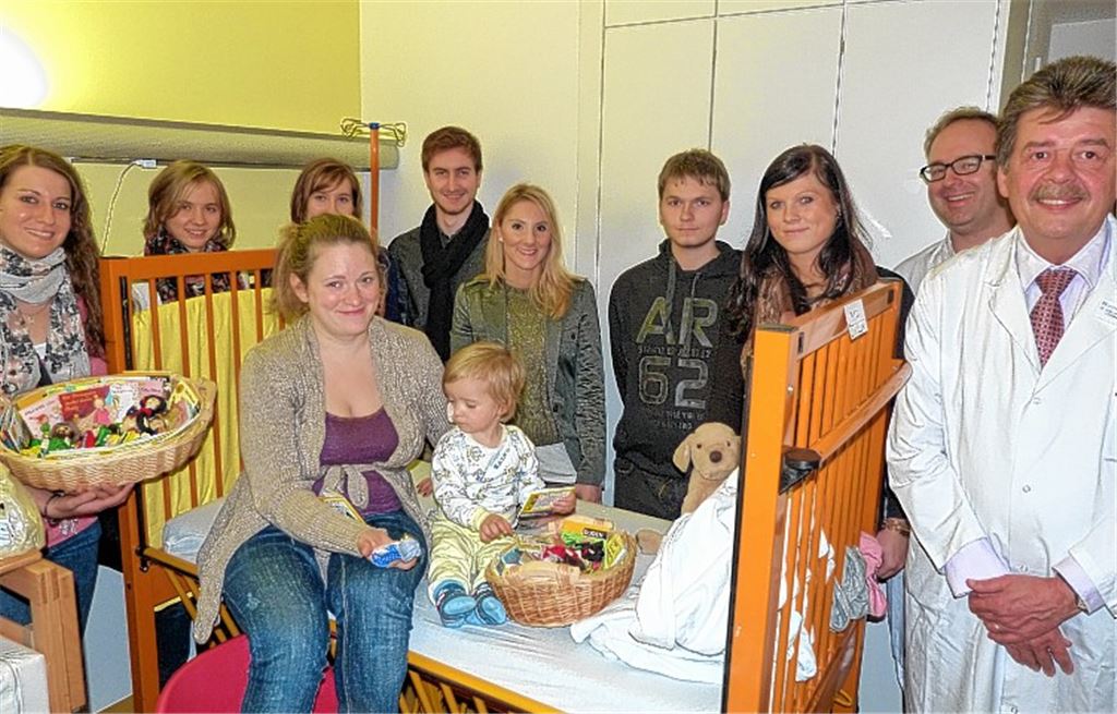 Der kleine Anton und seine Mutter freuen sich über die Geschenke, die Katrin Seyfried, Britt Abrecht, Katrina Krüger, Clemens Krüger, Belgin Celik, Luca Verdesca und Nastja Antonewich (v.li.) gebracht haben. Die Chefärzte Dr. Thomas Ringle und Dr. Hans-Ludwig Reiter (re.) freuen sich mit.