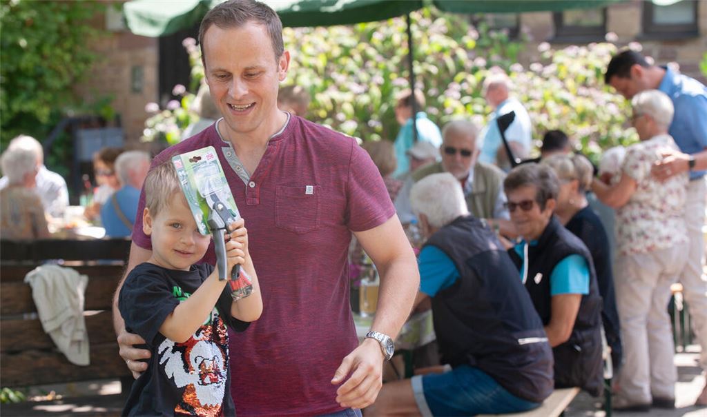 Der kleine Noah freut sich gemeinsam mit seinem Papa Thomas Czop über den Losgewinn, eine Gartenschere. Foto: Fotomoment