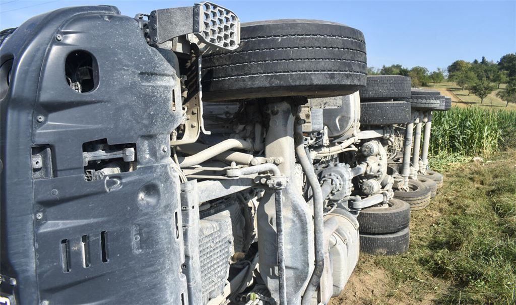Der mit Kies beladene Lkw kippt neben der Straße in ein Feld. Foto: Myroshnichenko