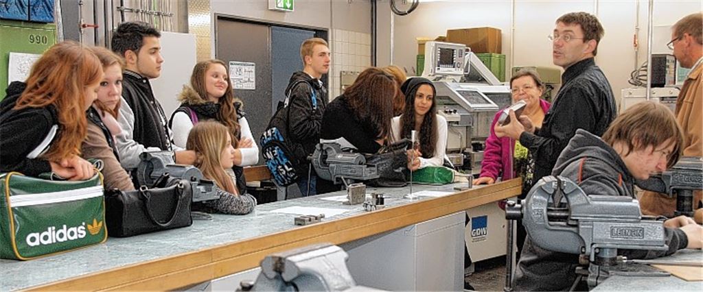 Der technische Lehrer Michael Siegrist (re.) zeigt den Schülern die Metallwerkstatt. Vor Ort bekommen sie eine Ahnung davon, was sie im Rahmen einer Ausbildung erwarten könnte.