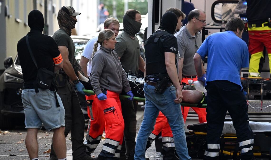 Der verletzte Tatverdächtige, der eine Lehrerin mit einem Messer angegriffen haben soll, wird zu einem Rettungswagen gebracht.