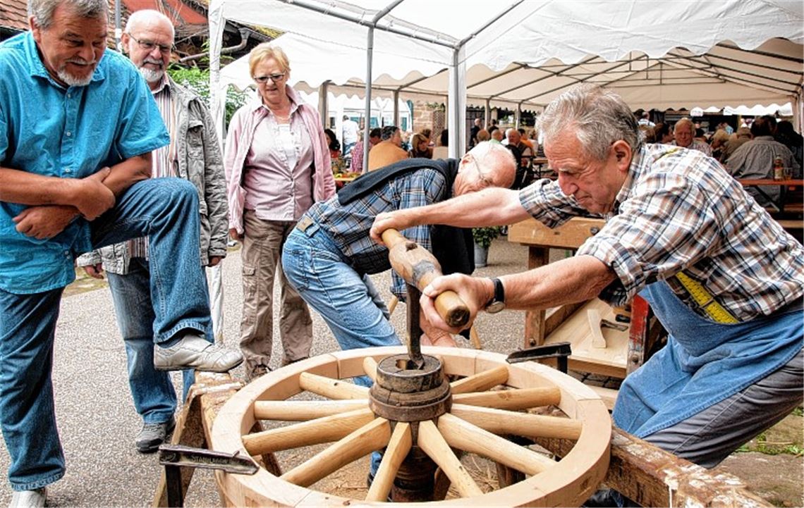 Die Arbeit als Wagner verlangt Muskelschmalz, das demonstriert der Oberderdingen Karl Renz. Das rechte Bild zeigt einen „Schwarzerd-Schmied“ bei der Arbeit. Fotos: Appich