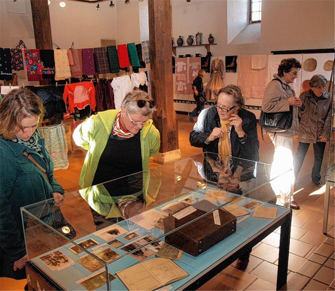 Die Besucher betrachten die ausgestellten Exponate. Bild rechts: Museumsleiterin Adelheid Teschner (2.v.re.) führt die erste Gruppe durch die Ausstellung.