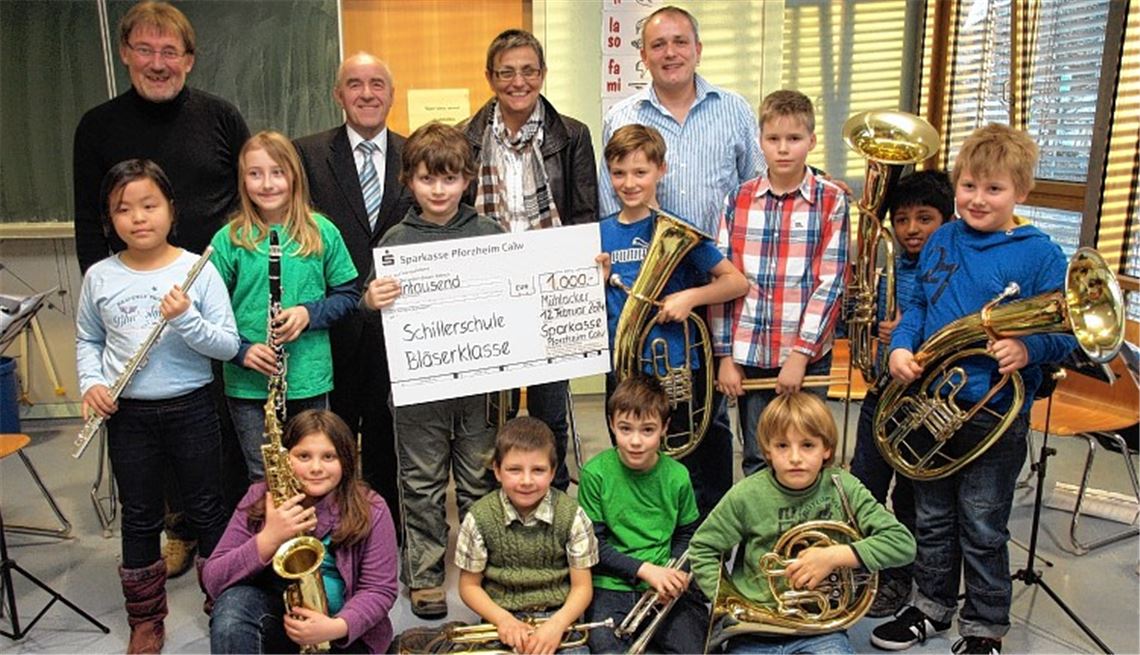 Die Bläserklasse und ihre Betreuer nehmen die Spende von ObenAuf-Geschäftsführer Wagner (hinten, 2. v. li.) entgegen.