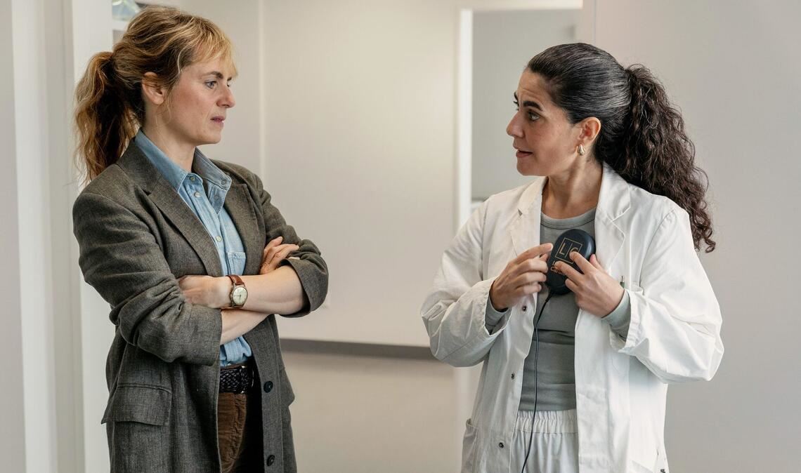 Die Chefärztin  erklärt, wie das Update eines ICD-Geräts funktioniert: Kommissarin Isabelle Grandjean (Anna Pieri Zuercher) und Dr. Esme Şahin (Beren Tuna).