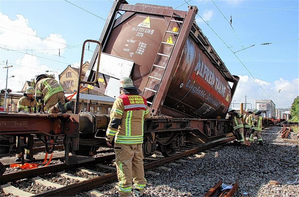 Die Einsatzkräfte sichern den aus der Halterung gesprungenen Tank mit Spanngurten, um ihn wieder aufzurichten. 