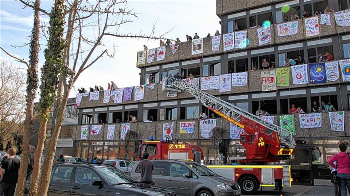 Die Feuerwehr hilft beim Anbringen der Glückwunschplakate an der THG-Fassade.