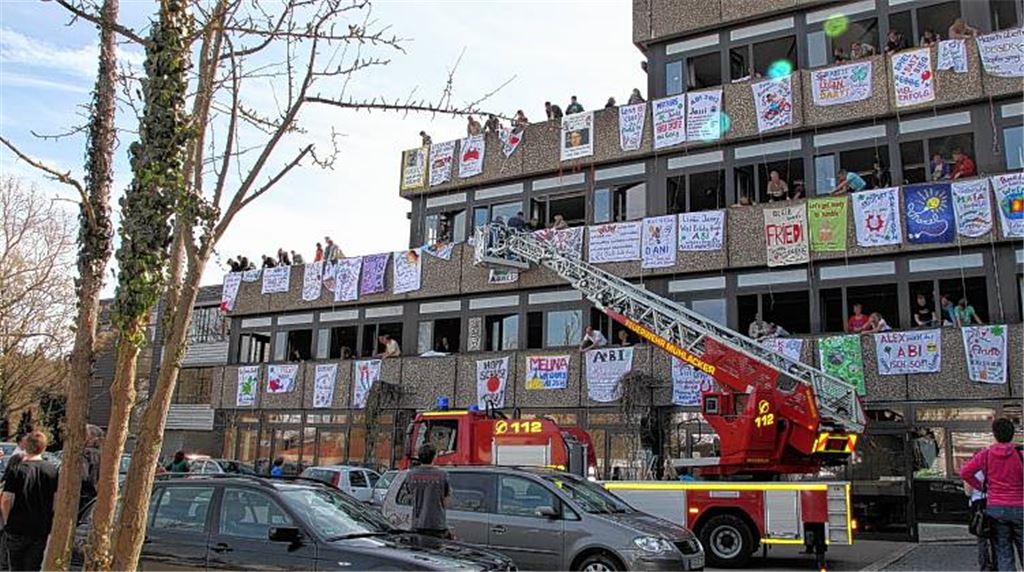 Die Feuerwehr hilft beim Anbringen der Glückwunschplakate an der THG-Fassade.