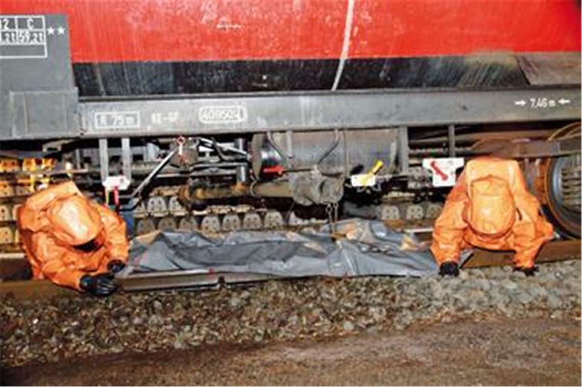 Die Floriansjünger kriechen unter den Waggon, um dort eine Schutzfolie auszubreiten, damit die giftige Flüssigkeit nicht ins Erdreich versickern kann. Fotos: Appich