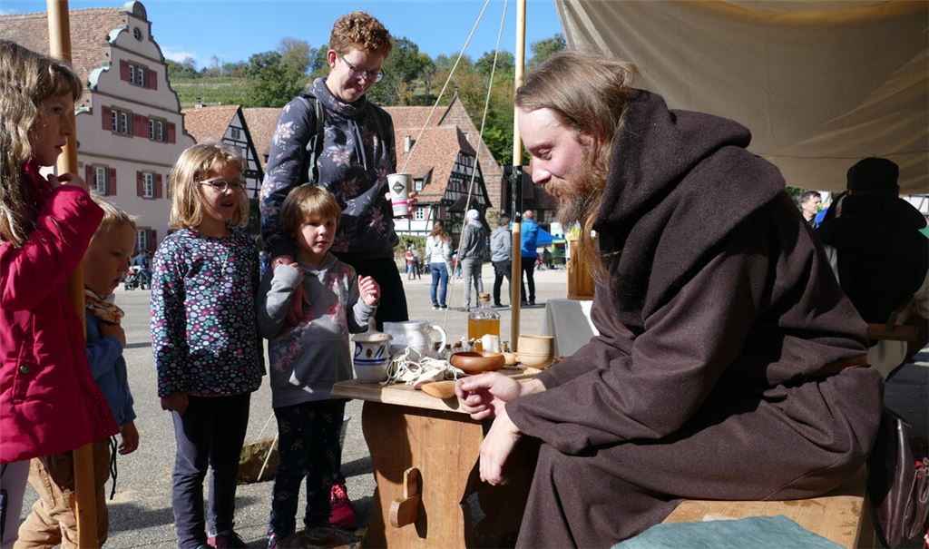 Die Gäste bewundern die grobe braune Kutte eines Mittelalterfreundes, der vor Augen führt, wie die sogenannten Laienmönche im Kloster gekleidet waren. Fotos: Weimper