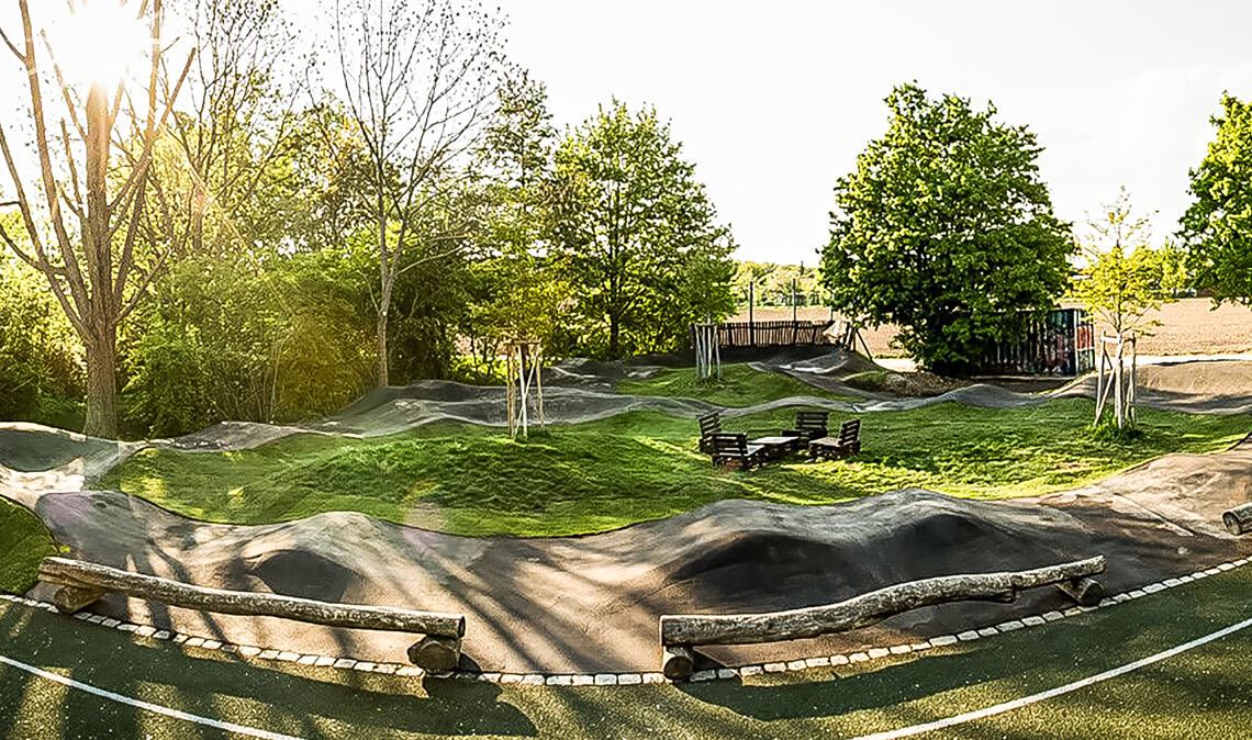 Die Gebäude der früheren Gärtnerei Keefer in den Enzgärten sollen abgerissen werden. Für die Neugestaltung der Fläche bringt der Gemeinderat neben einer Blühwiese mit Bäumen einen kleinen Pumptrack für junge Biker ins Spiel. Hier ein Beispiel für solch eine Anlage aus Stuttgart-Weilimdorf. Fotos/Skizzen: privat/www.pumptrack.de