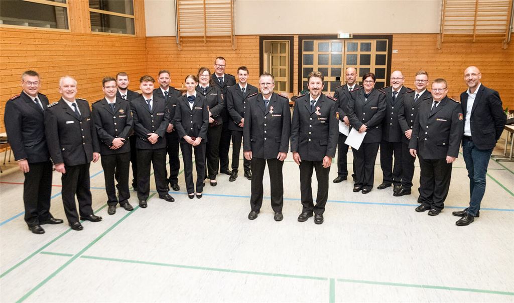 Die Geehrten Uwe Kiefer und Bernd Schäfer (vorne v. li.) mit den Beförderten und den Vertretern von Feuerwehr und Gemeinde. Fotos: Fotomoment