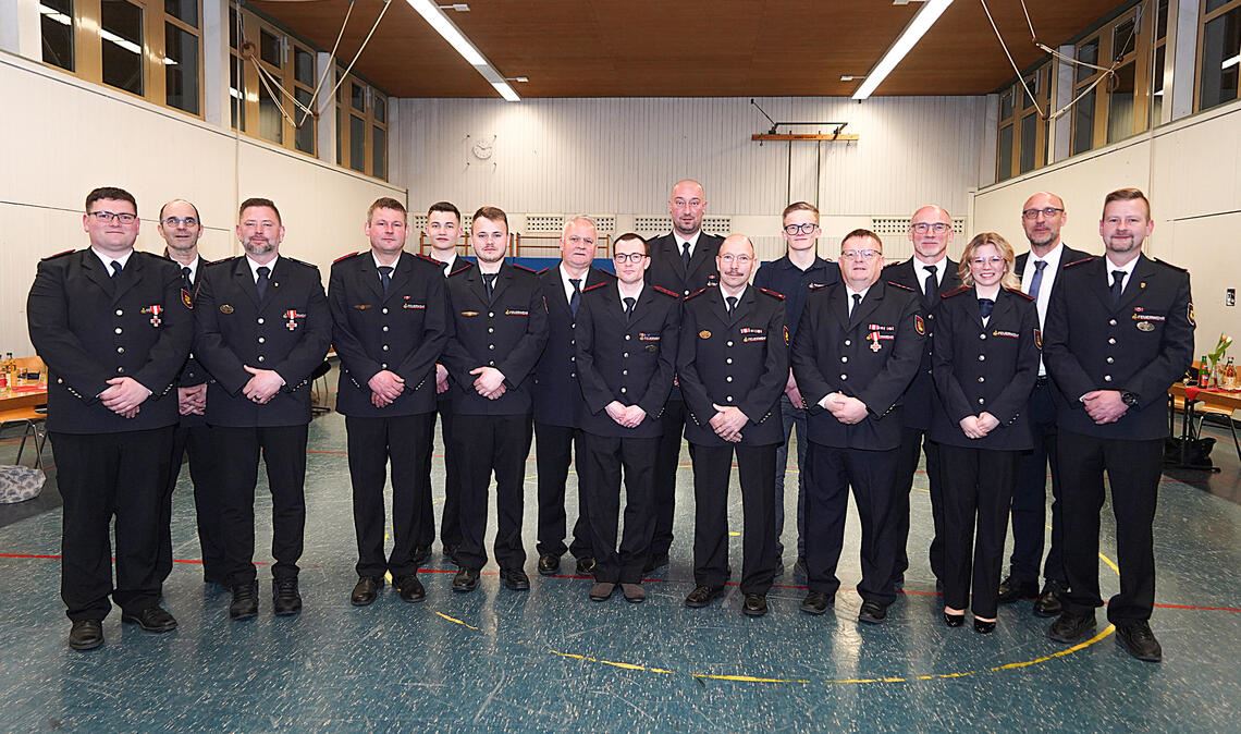 Die Geehrten und Beförderten (v.li.): Jérémie Paupy, Kreisbrandmeister-Stellvertreter Martin Irion, Thomas Meier, Oliver Schweickert, David Schweickert, Marvin Schäfer, Markus Schäfer, Nico Penzinger, Christian Schrenk, Wolfgang Albrecht, Julian Braun, Jürgen Braun, Klaus Riekert vom Verband, Angelina Walter, Bürgermeister Norman Tank und Kommandant Dominik Schweickert. Foto: Roller