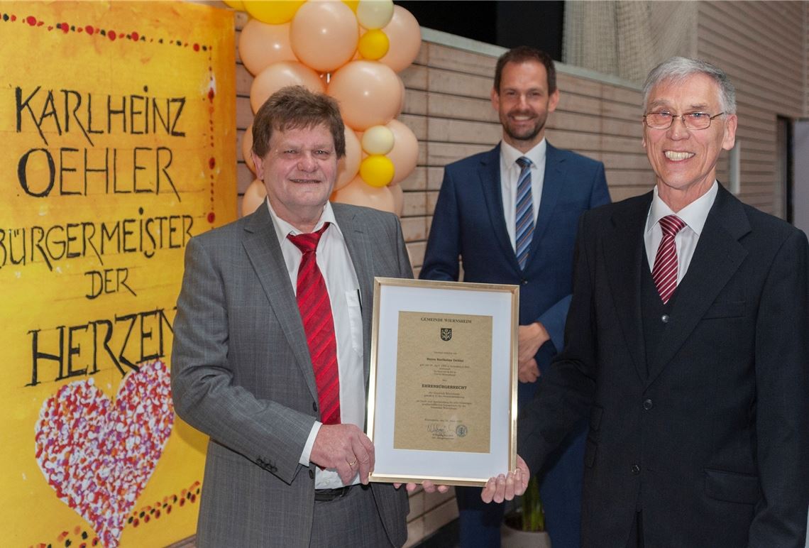 Schultes-Original emotional verabschiedet „Die Gemeinde geprägt und Maßstäbe gesetzt“ hat Karlheinz Oehler laut Landrat Bastian Rosenau (Mitte). Die Urkunde, ausgehändigt durch Wolfgang Hanisch (re.), würdigt Oehlers Wirken zu Lebzeiten – ein Novum für Wiernsheims dritten Ehrenbürger.Foto: Fotomoment