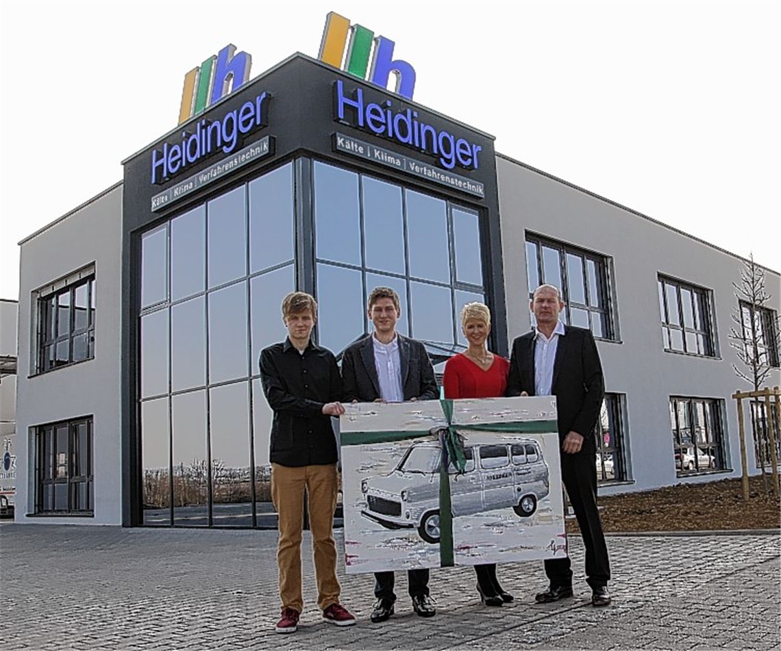 Die Geschäftsführer Frieder (rechts) und Karin Heidinger mit ihren Söhnen Julian (li.) und Adrian mit einem Bild des ersten Firmenfahrzeugs, das später bei der offiziellen Feier zur Einweihung des Firmenneubaus in den Waldäckern dem Firmengründer als Geschenk überreicht werden soll. Foto: Sadler