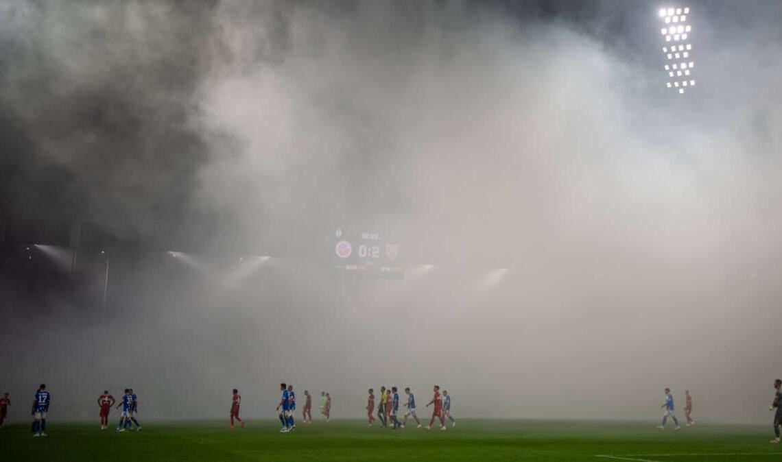 Die Hansa-Fans begleiten den Wiederanpfiff mit mehreren Rauchtöpfen, die die Sichtverhältnisse auf dem Platz trüben. Der Unparteiische unterbricht daher die Partie für mehrere Minuten.
