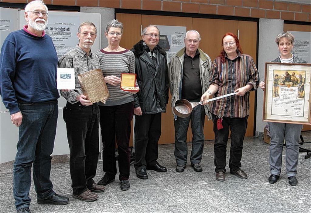 Die Initiatoren und Unterstützer der Ausstellung mit den ehemaligen Emrich-Mitarbeitern Franz Gischlar (3.v.re.) und Heinz Kraft (li. daneben) präsentieren einige der Leihgaben. Zu sehen sind im Rathaus von Montag an unter anderem historische Fotos wie die Familienaufnahme von 1928 mit (Bild oben v.li.) Alfred, Alice, Isidor und Richard Emrich, alte Gerätschaften und Dokumente.