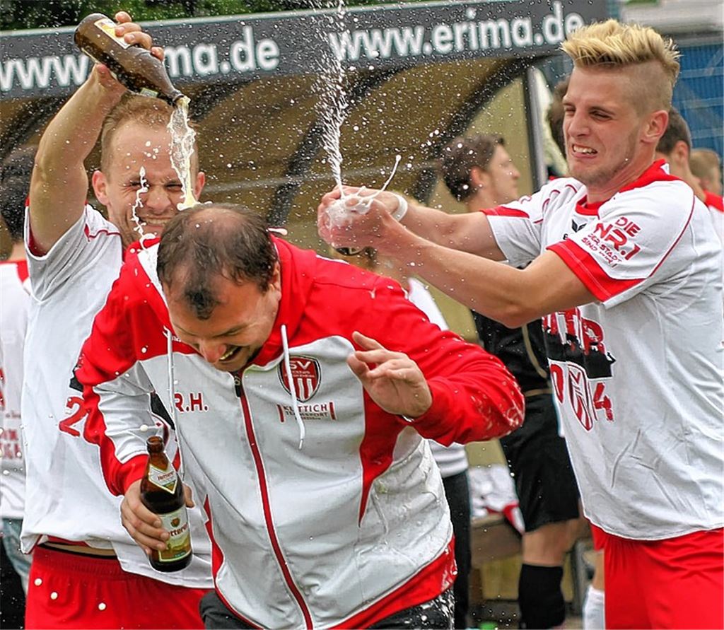 Die Kickers Pforzheim feiern die Meisterschaft in der Verbandsliga: Viktor Kärcher und Lukas Buck verabreichen Trainer Rudi Herzog eine Bierdusche. Foto: Rubner